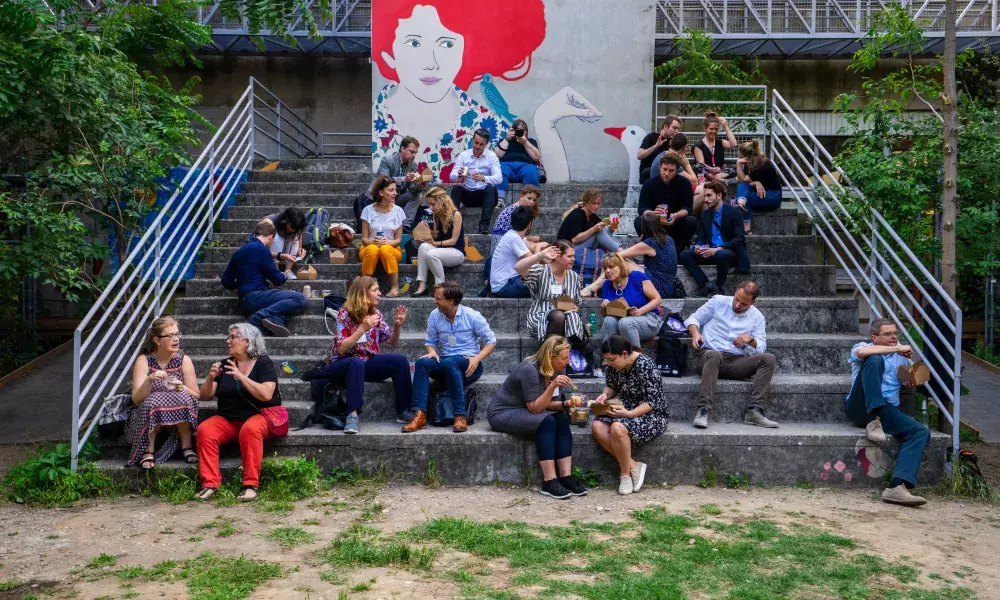 Picture representing people discussing and eating in an urban environment
