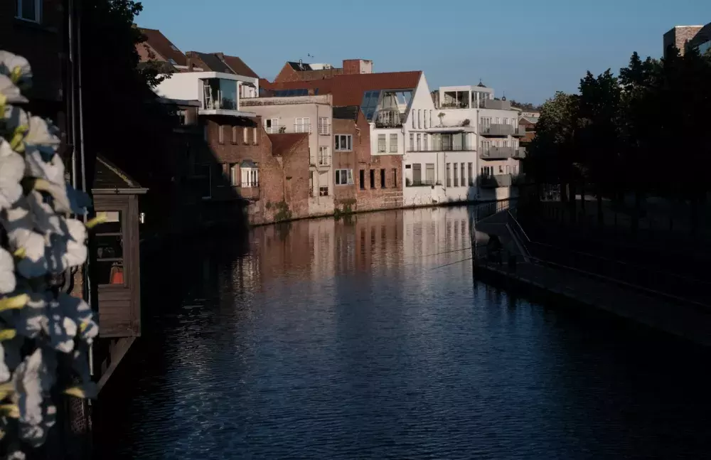 The Dijle in the city centre of Mechelen. The Dijlepad can be seen on the right with two fishing rods hanging over the water on a warm day in June 2024. (Photo by Johannes Riegler)