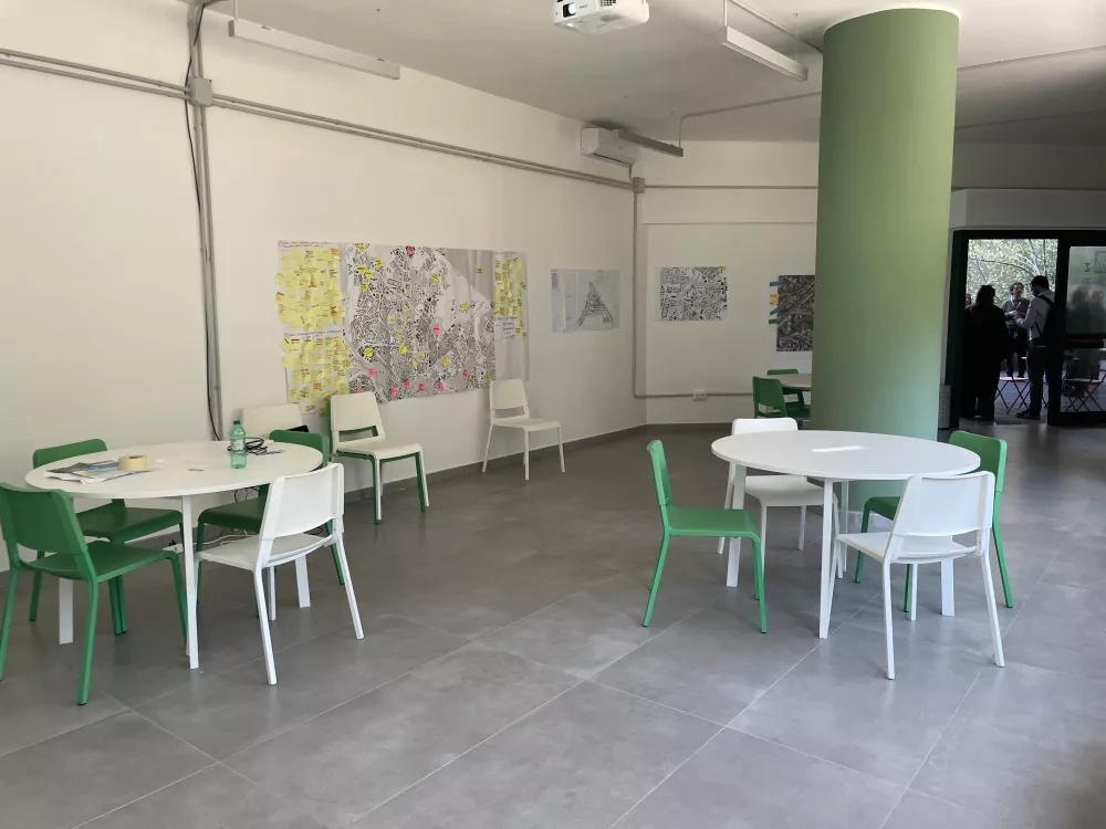 Inside the Living Lab, with round tables, and maps and workshop materials hanging on the walls