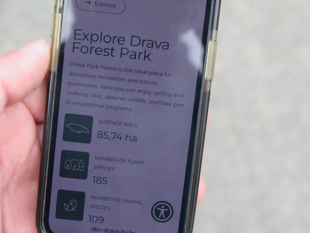cell phone withe the landing page of the platform "Explore Drava Forest Park"