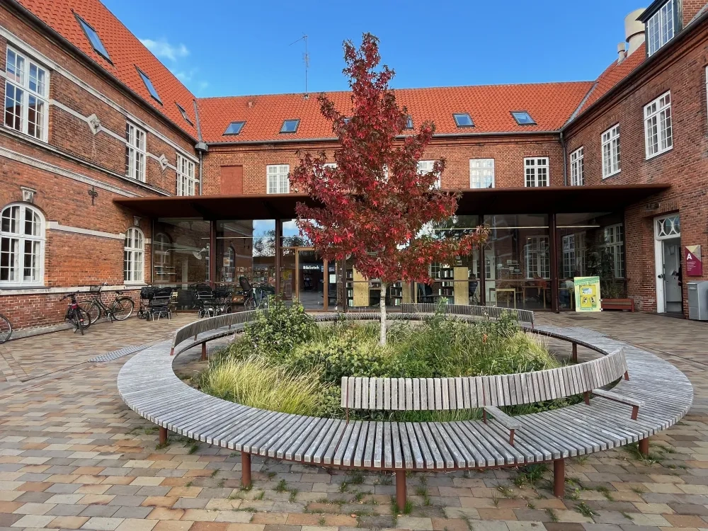 public library and cultural house, with a round-bench with a tree in the centre, in the front